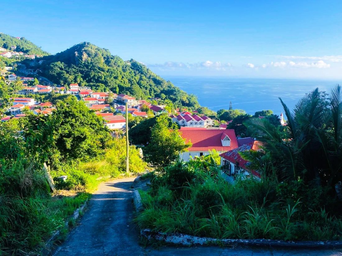 A lane winding down into Windwardside village on Saba, red-roofed homes above the Caribbean Sea